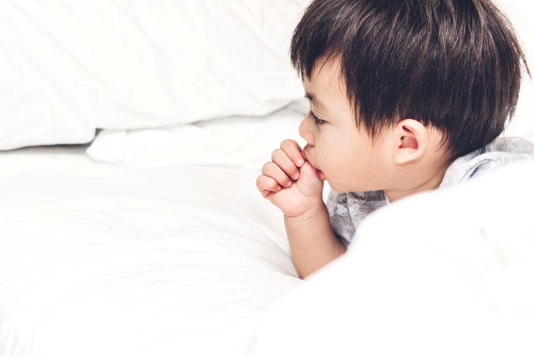 thumb sucking toddler in bed